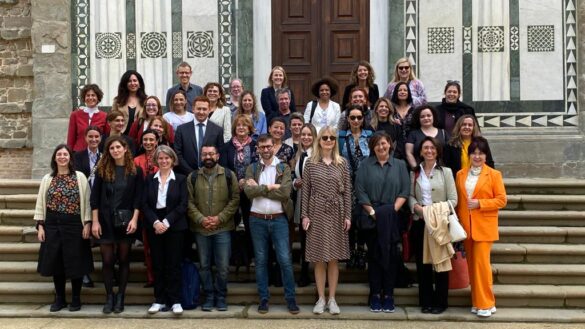 Un grup de oameni care pozează pentru o fotografie în fața unei clădiri.